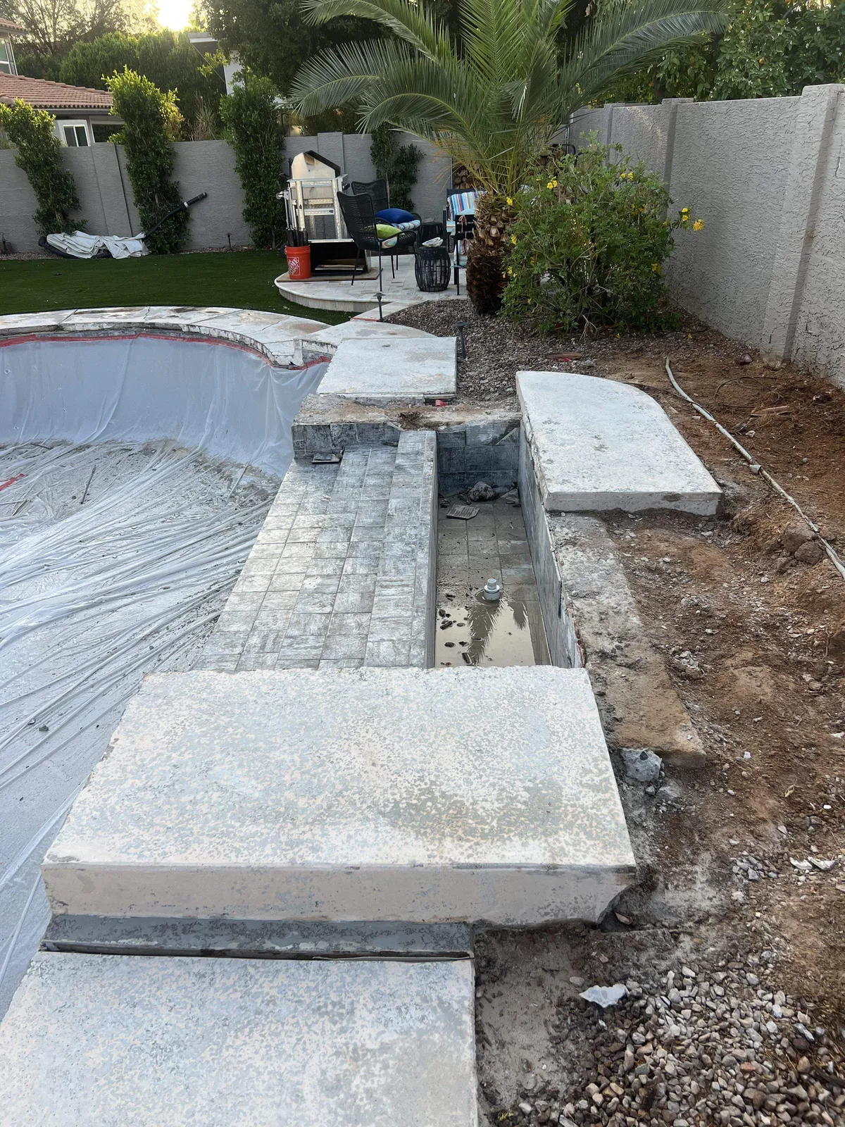 Drained pool and demolished spa steps during renovation before rebuild