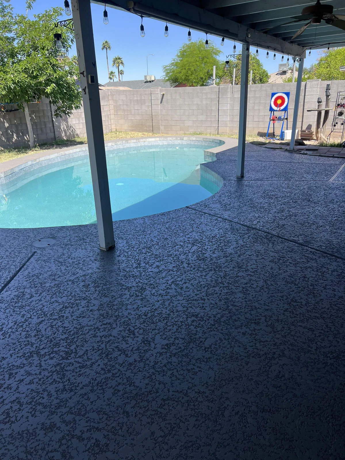 Resurfaced charcoal acrylic deck with channel drains running through the coating