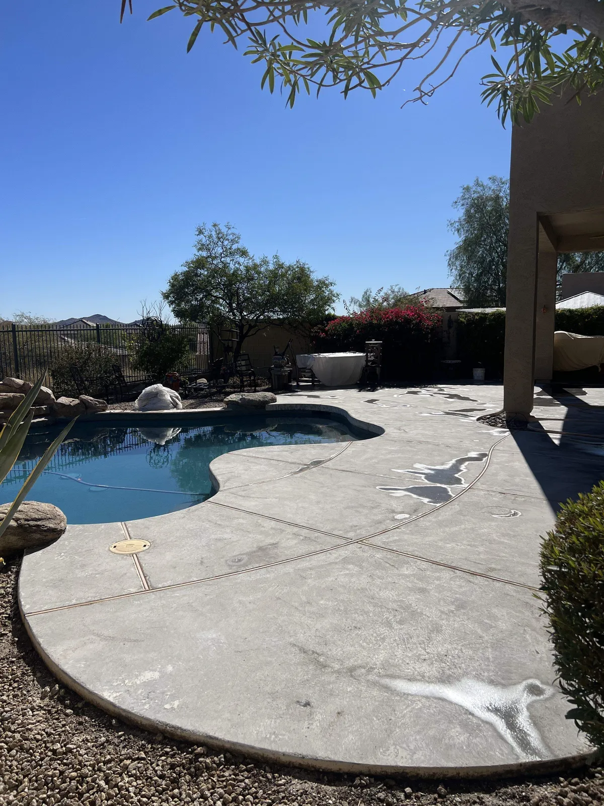 Plain gray concrete pool deck before resurfacing, Phoenix Valley home with desert view