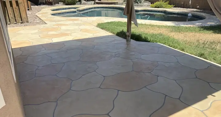 Tan flagstone coating connecting a covered patio to the pool