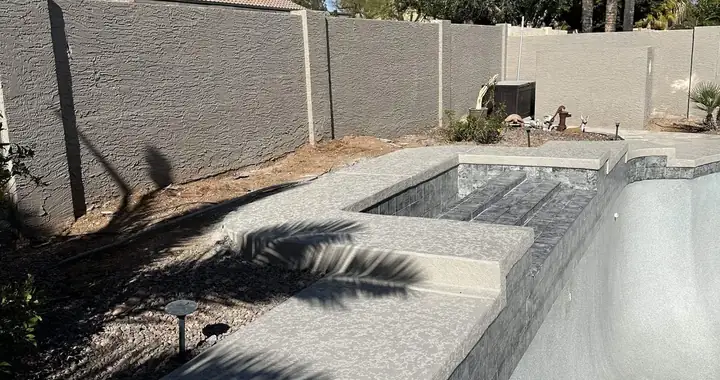 Raised spa spillway wall with a new gray texture coating, before the pool was refilled