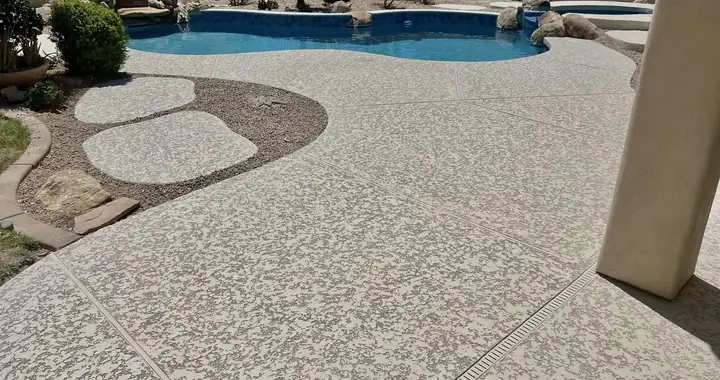 Light lace-texture coating on a curved pool deck, with stepping stones set in gravel beside it